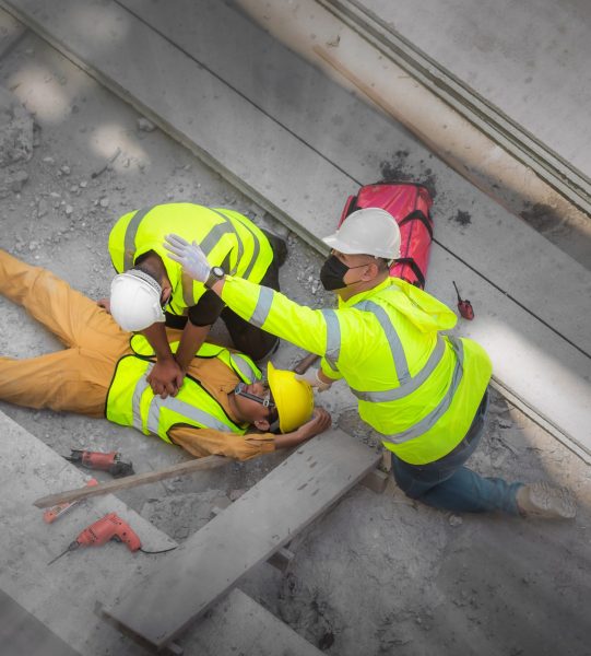 Basic First aid and CPR for Emergency Accidents at Construction Sites. Construction worker was injured in a fall from a height at construction site. Safety team and engineers help to perform first aid
