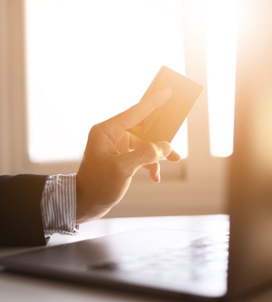 Hands of a businessman using laptop and card on the internet