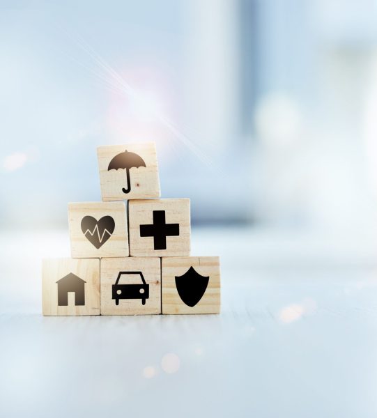 Healthcare, insurance and medical with building blocks on desk in hospital for future planning or wellness. Medicine, pyramid and stack with symbol icons in clinic for life cover, finance or security.